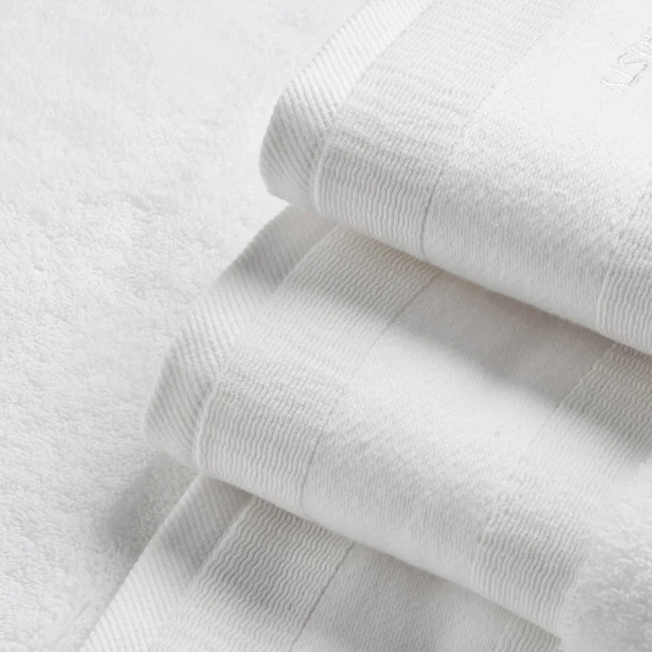 Stack of white textured towels on a light gray background