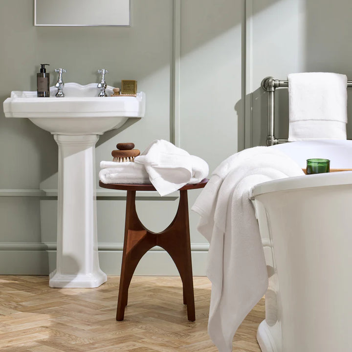 Bathroom with a sink, stool, and towel rack.