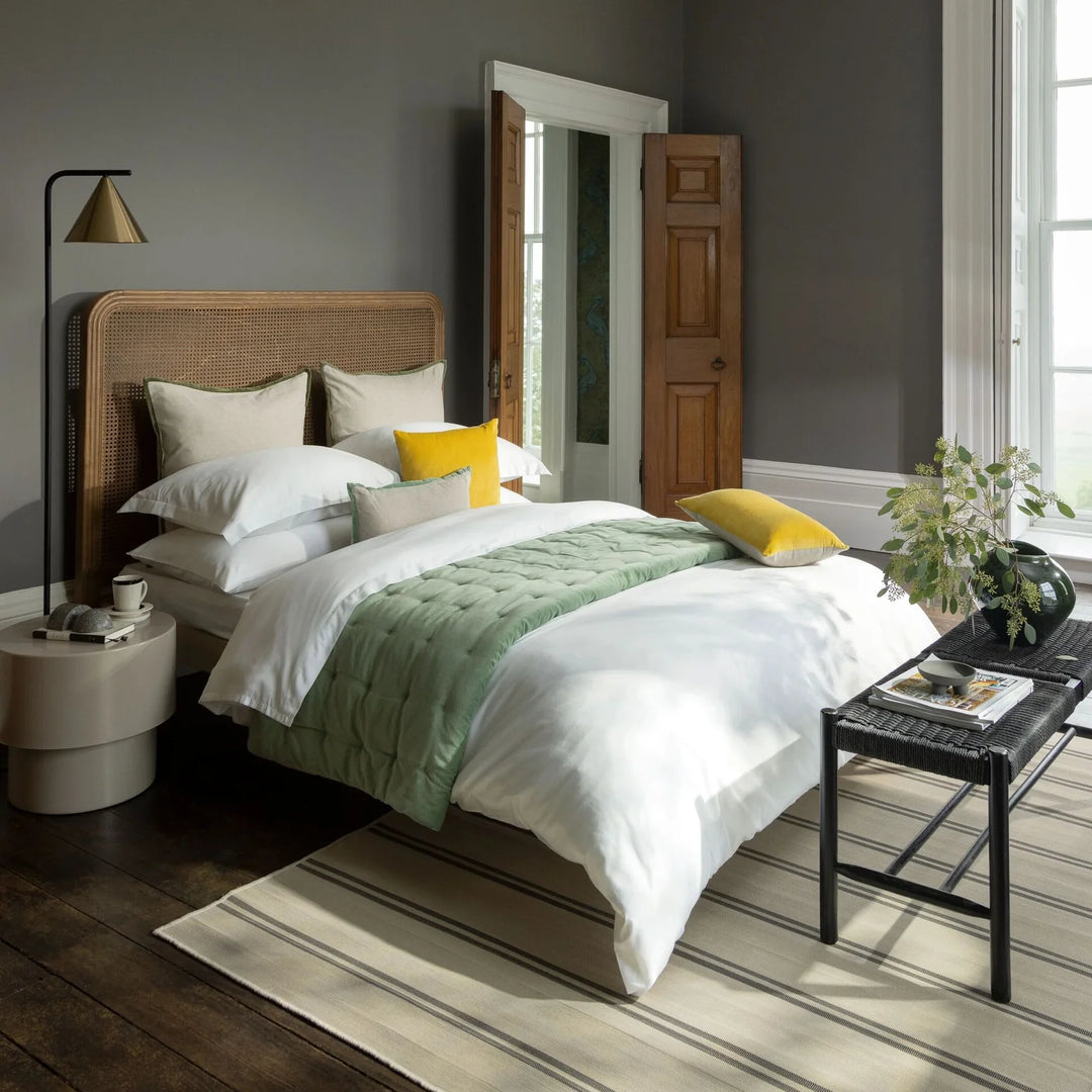 Modern bedroom with a bed, side table, and lamp.