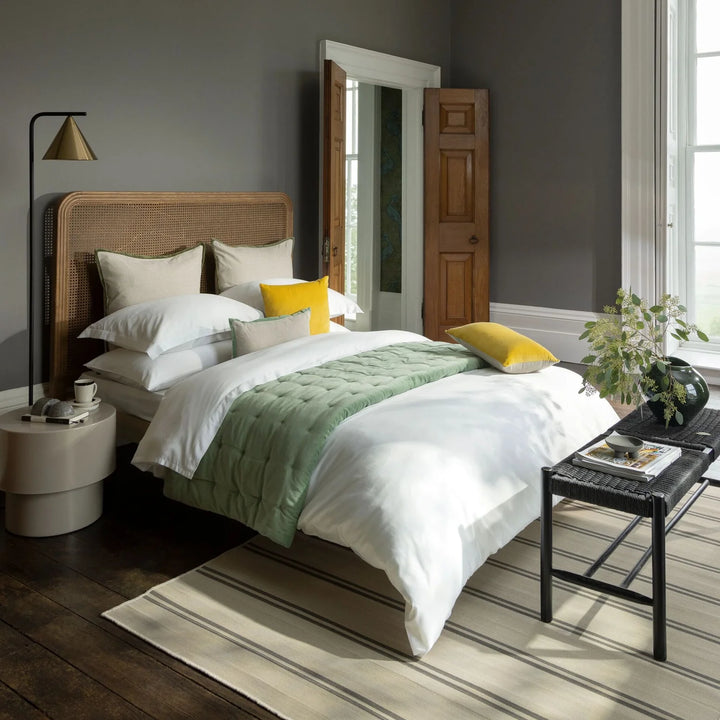 Modern bedroom with a bed, side table, and lamp.