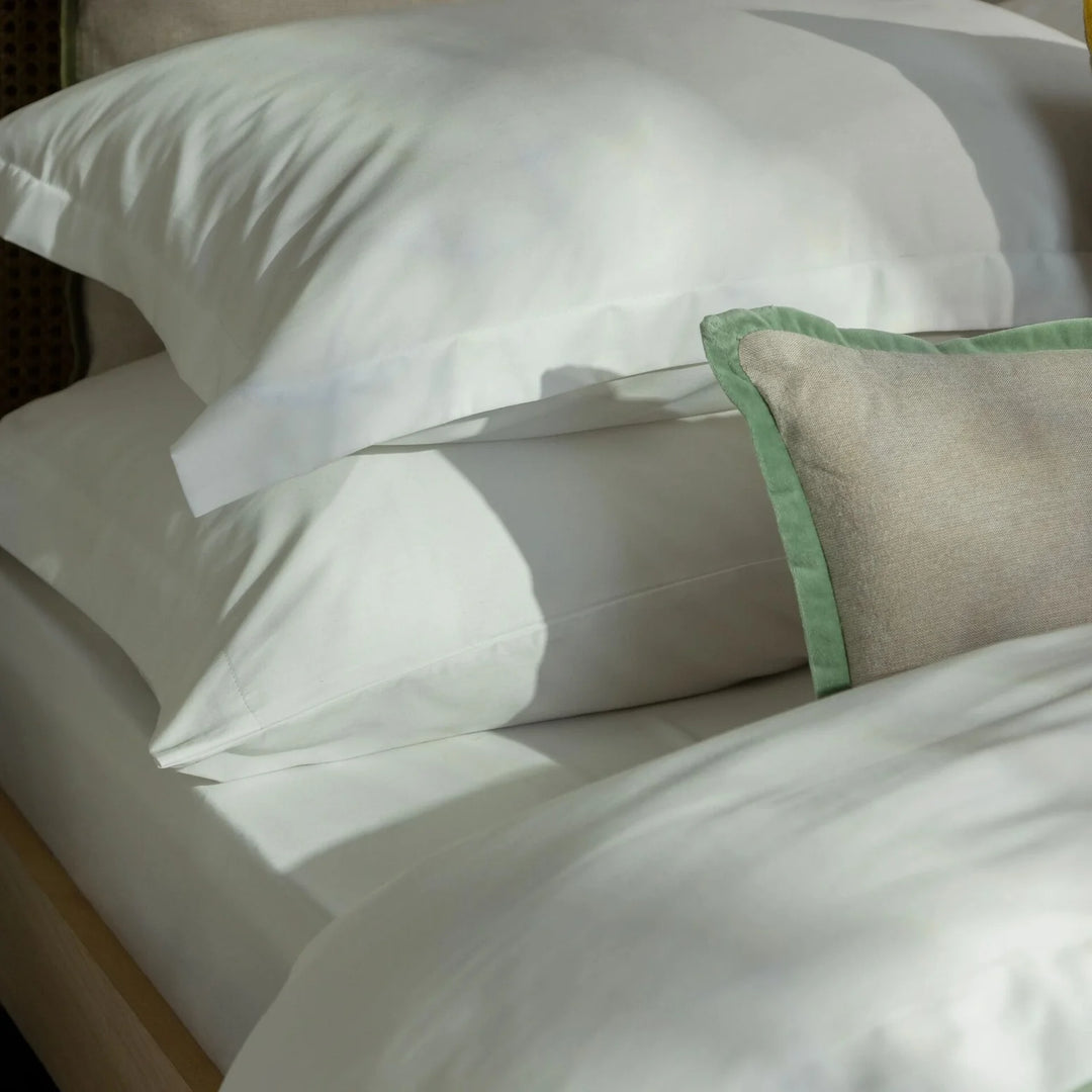 Close-up of neatly arranged pillows on a bed with a soft focus effect.