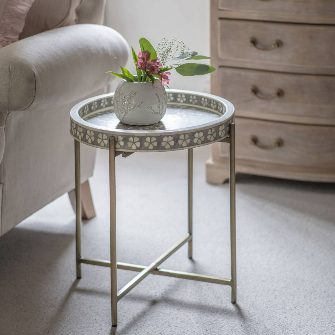 Small round table with decorative legs in a living room setting