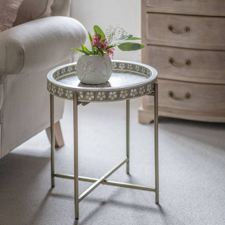 Small round table with decorative legs in a living room setting
