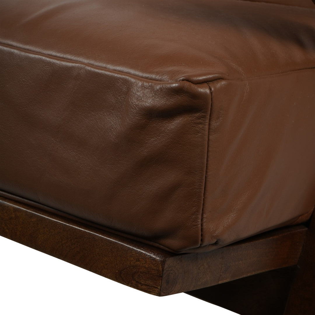 Close-up of a brown leather sofa corner on a white background