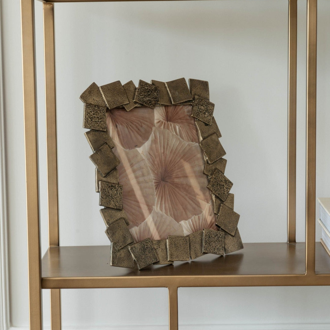 Decorative vase with textured surface on a gold shelf