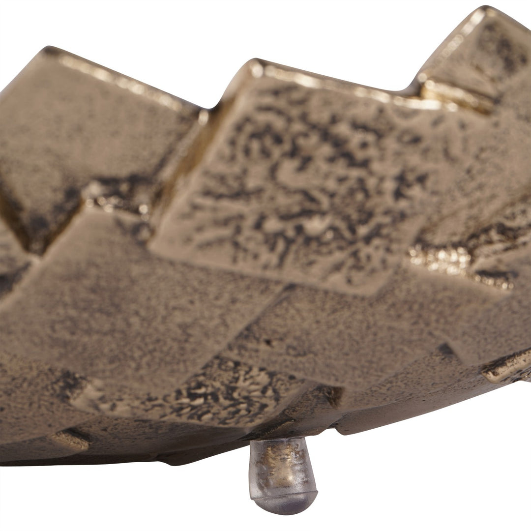 Close-up of a metallic object with intricate patterns on a white background