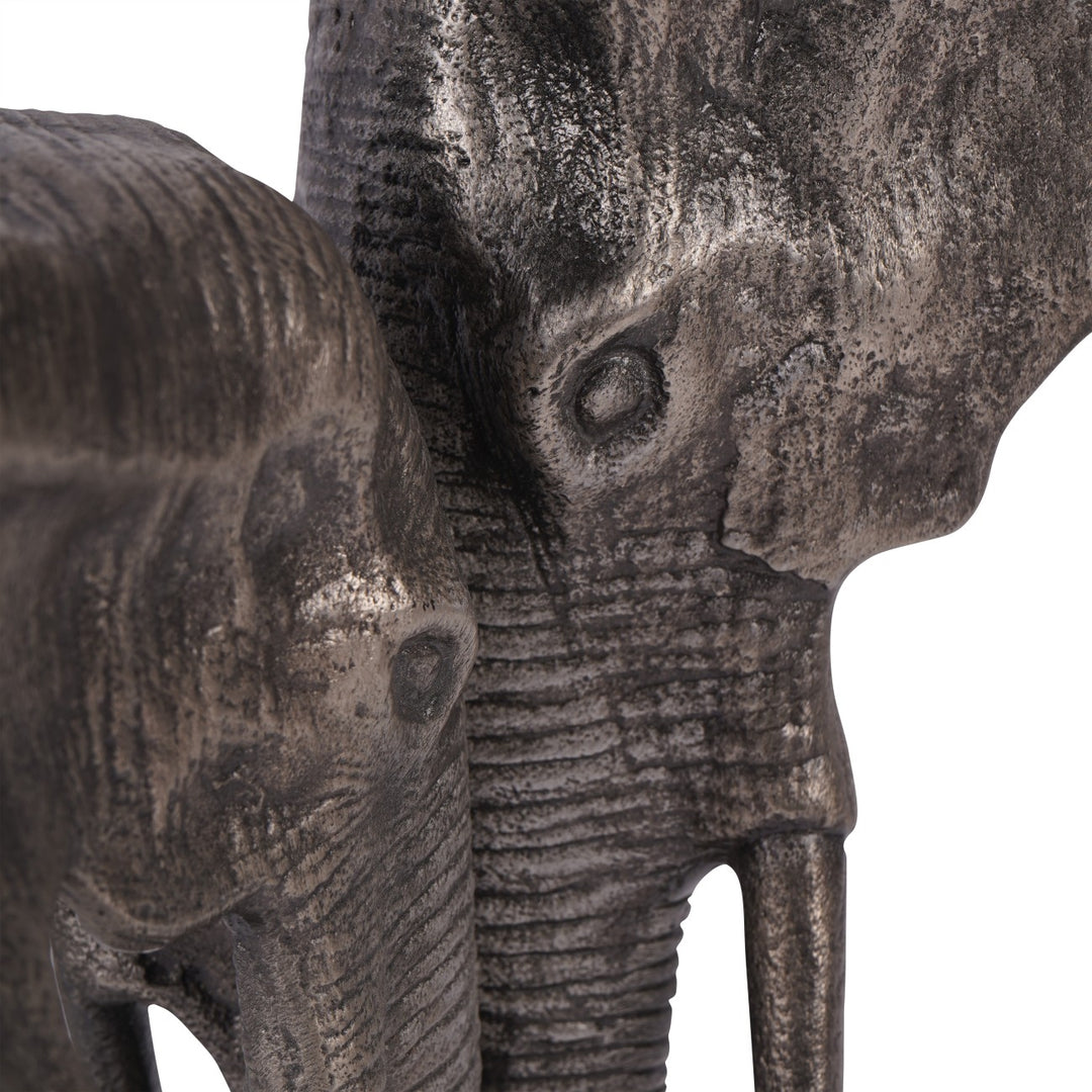 Close-up of two stone elephant sculptures against a white background