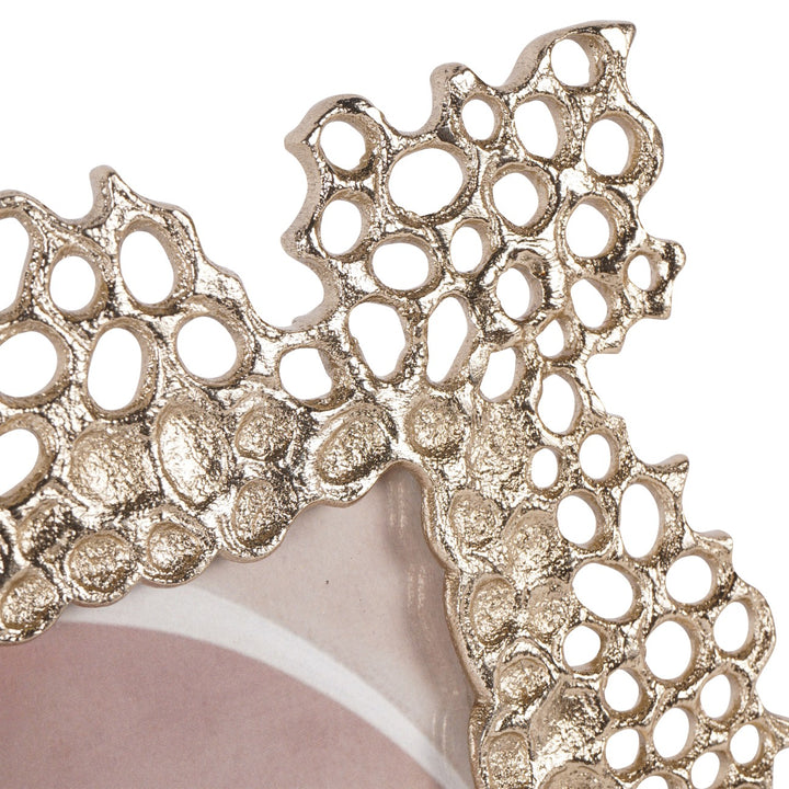 Close-up of a decorative gold lace-like object on a white background