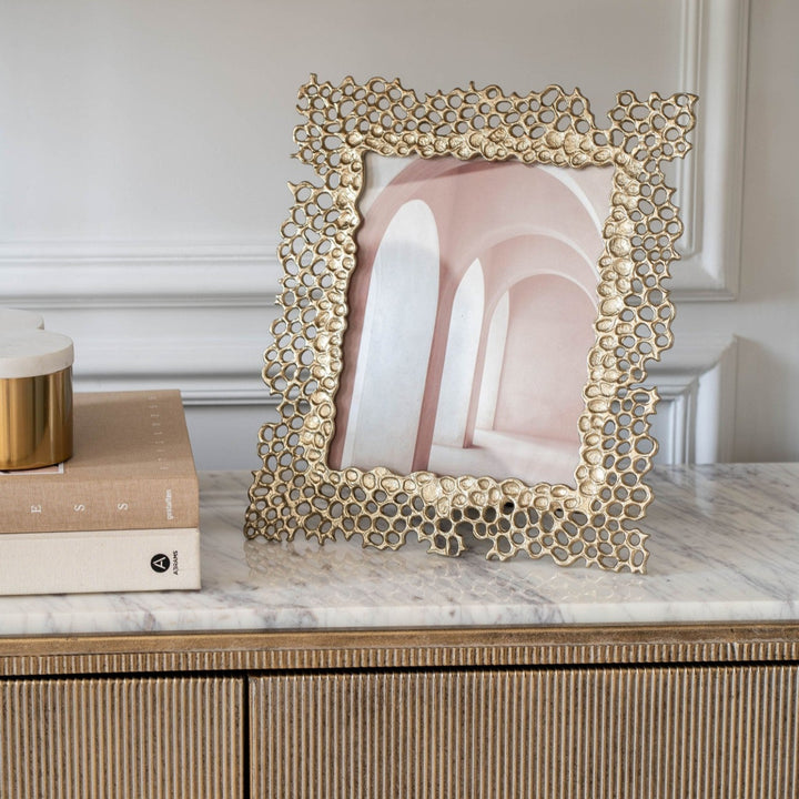 Decorative gold frame with a marble background on a wooden surface
