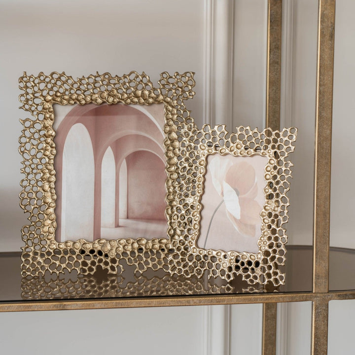 Decorative gold frame with a honeycomb design on a shelf.
