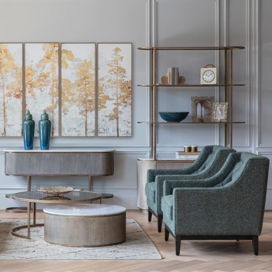 Modern living room with gray armchairs, round coffee table, and decorative wall art.
