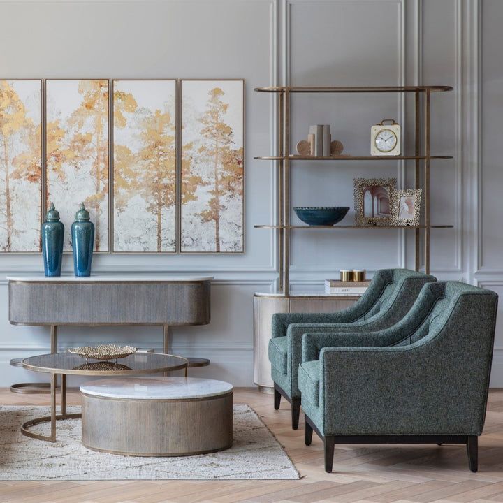 Modern living room with gray armchairs, round coffee table, and decorative wall art.