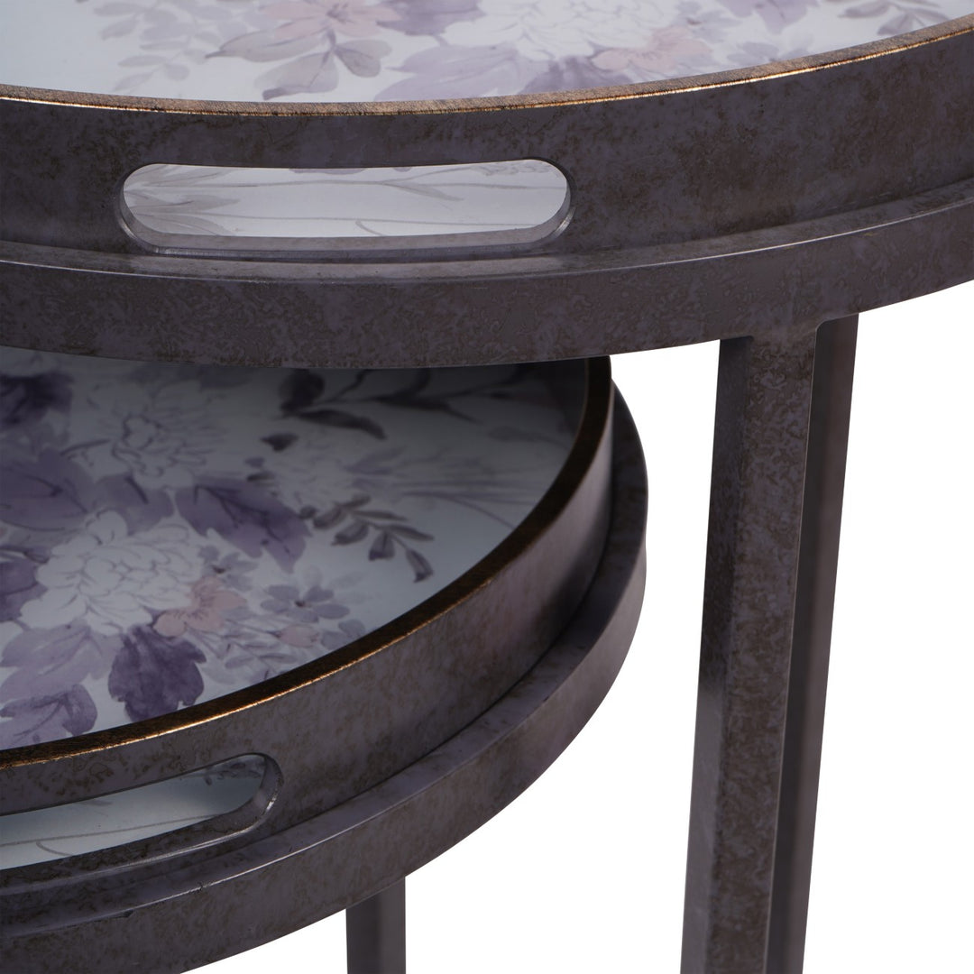 Round metal table with floral-patterned glass top on a white background