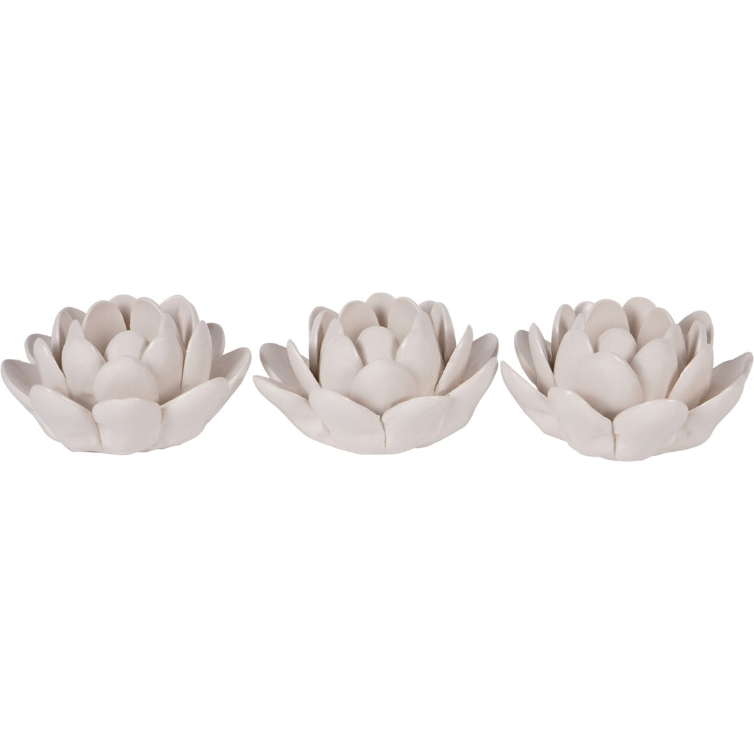 Three white ceramic lotus flower ornaments on a white background