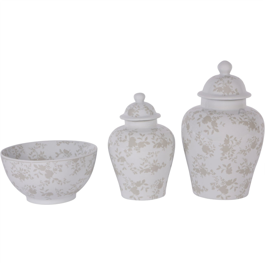Set of three white ceramic jars with floral patterns on a white background
