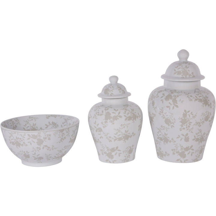 Set of three white ceramic jars with floral patterns on a white background