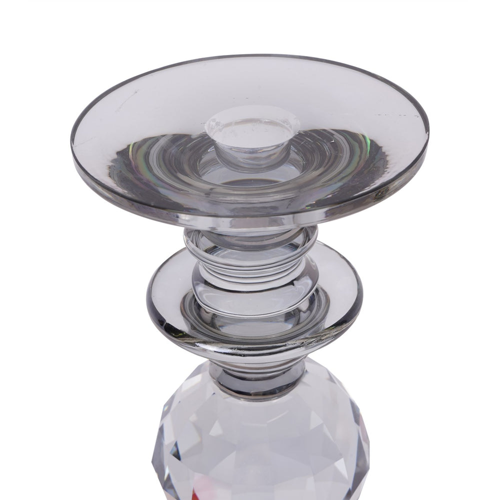 Clear glass candle holder with a faceted base on a white background