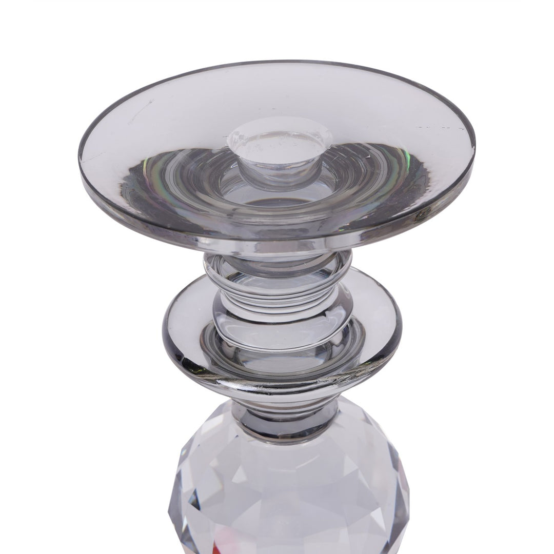Clear glass candle holder with a faceted base on a white background