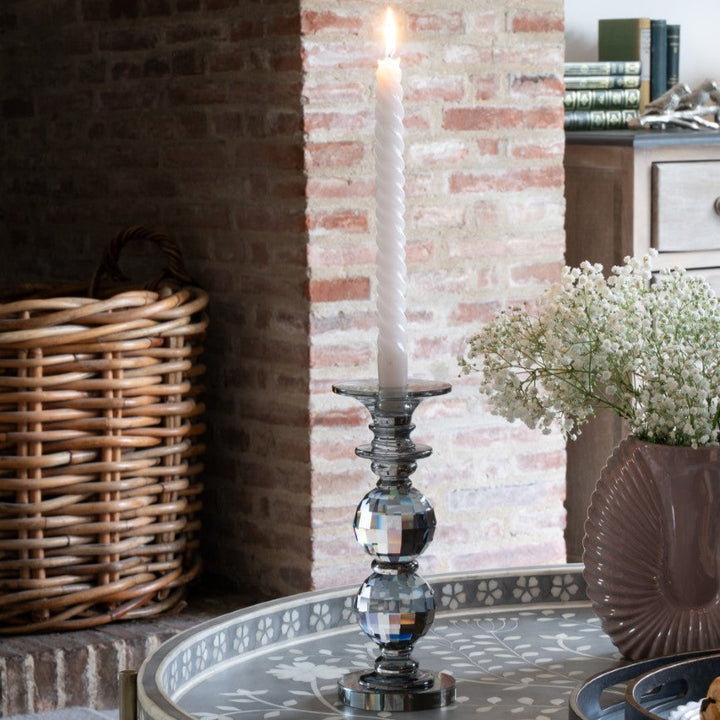 Decorative candle holder on a round table with a brick wall background