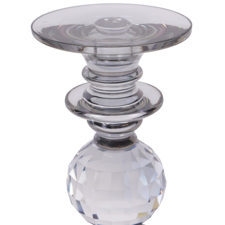 Clear glass candle holder with a faceted base on a white background