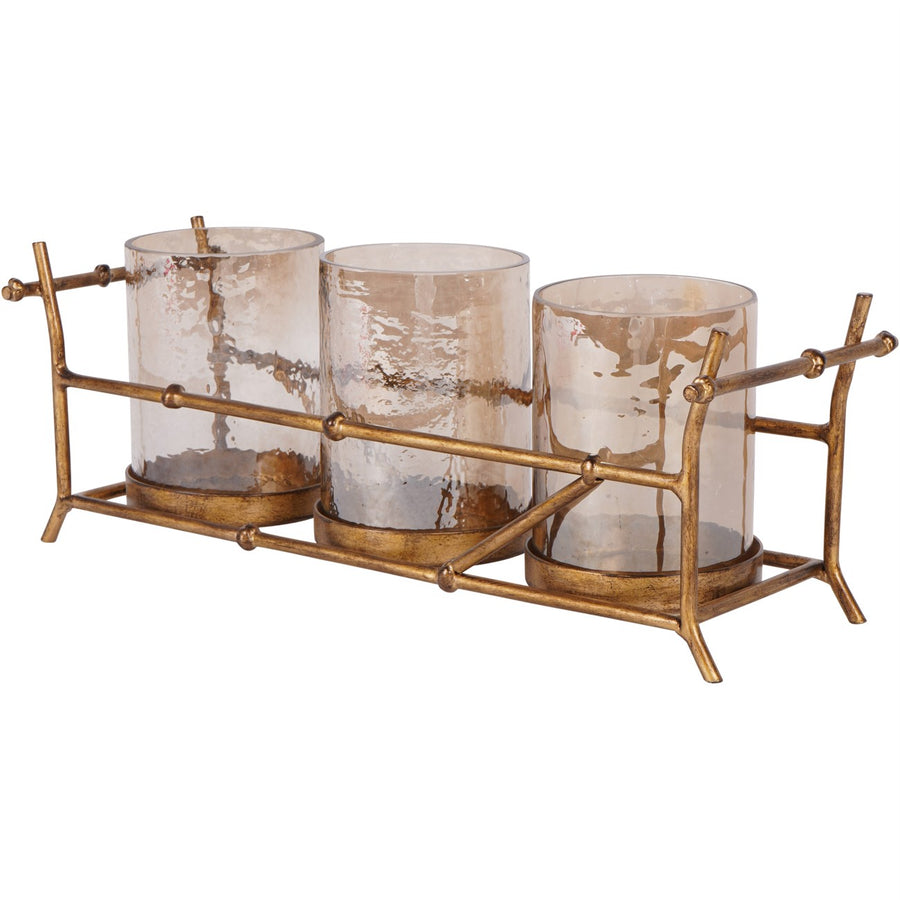 Decorative candle holder with three glass candles and a gold metal stand on a white background