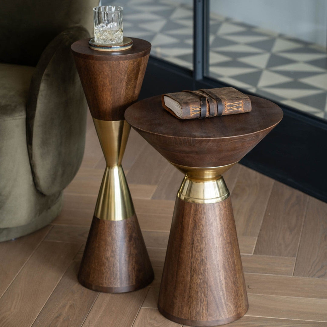 Two wooden side tables with gold accents on a wooden floor.