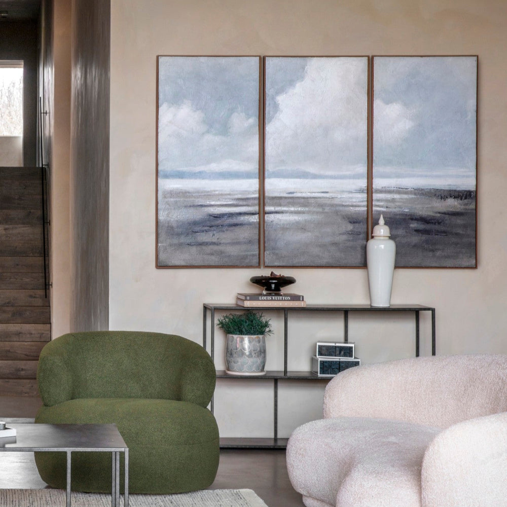 Modern living room with green armchair, white sofa, and abstract wall art.