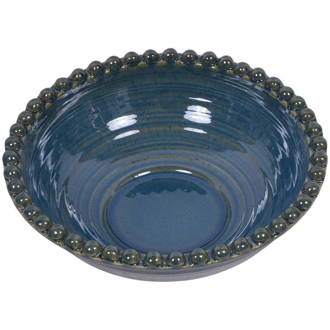 Blue ceramic bowl with green bead-like rim on a white background