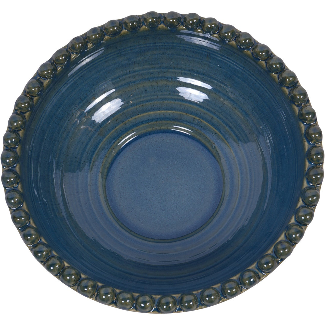 Blue ceramic bowl with decorative edge on a white background