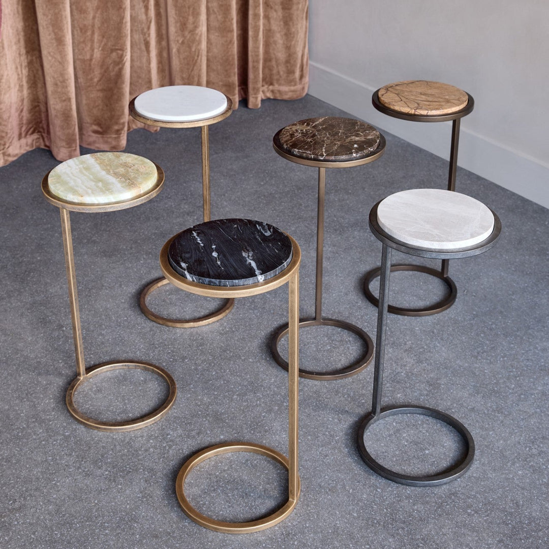 Set of Libra Iota Accent Tables with marble-like tops on a gray floor.