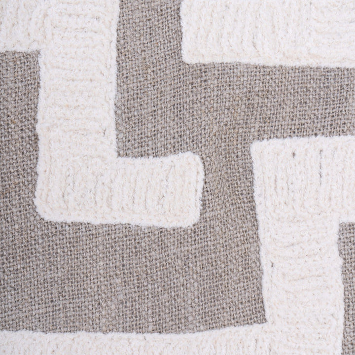 Close-up of a textured cushion with geometric pattern in grey and white.