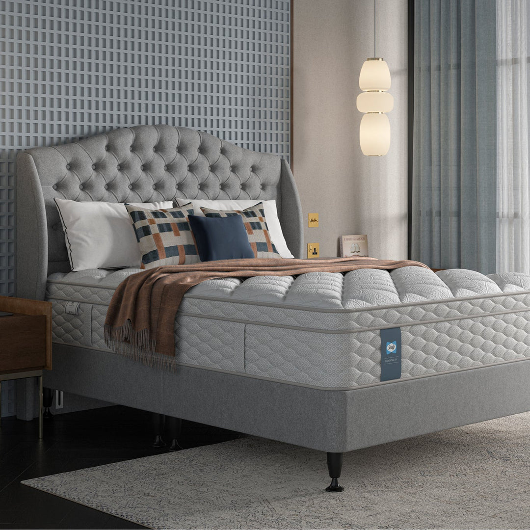 Sealy Aristocrat mattress in a hotel bedroom setting with decorative pillows and lamps