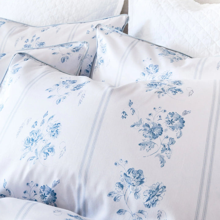 White bedding set with blue floral patterns on a white background