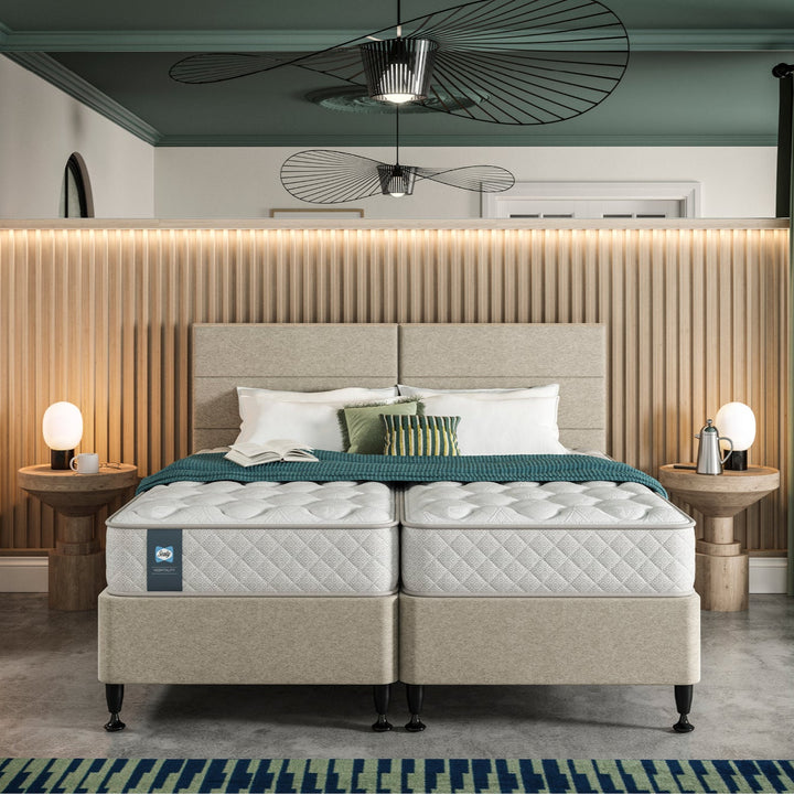 Hotel bedroom with a bed featuring a Sealy Duke mattress and pillows