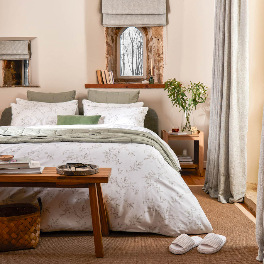 Cozy bedroom with a bed, wooden side table, and decorative elements.