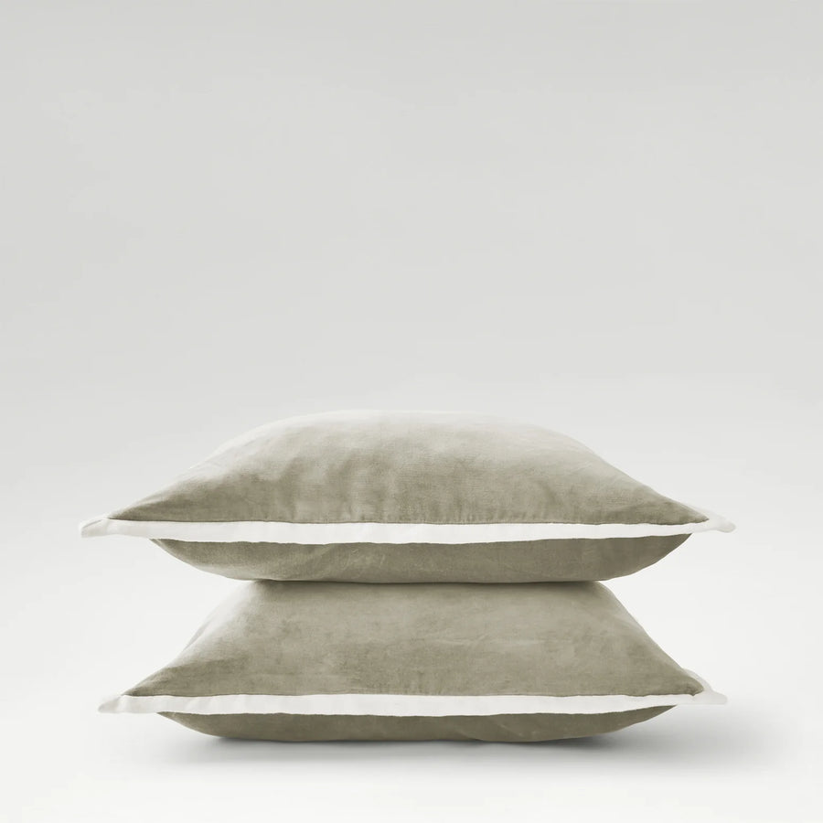 Two stacked pillows with a white border on a light gray background