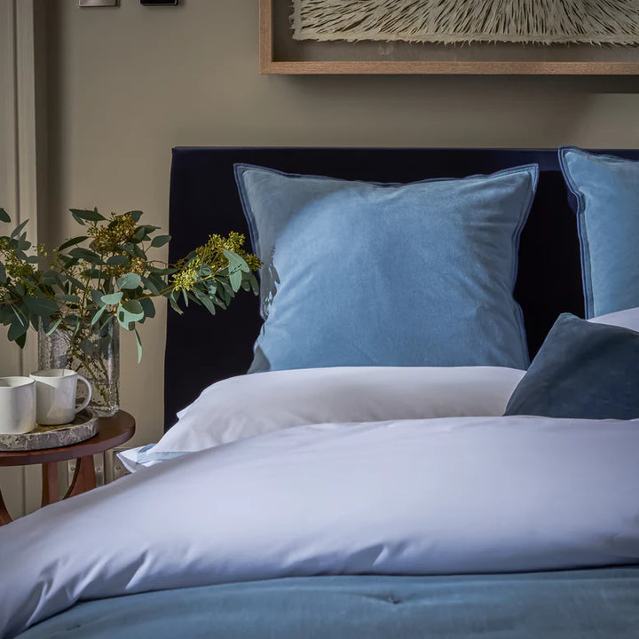 Bed with blue and white bedding in a bedroom setting