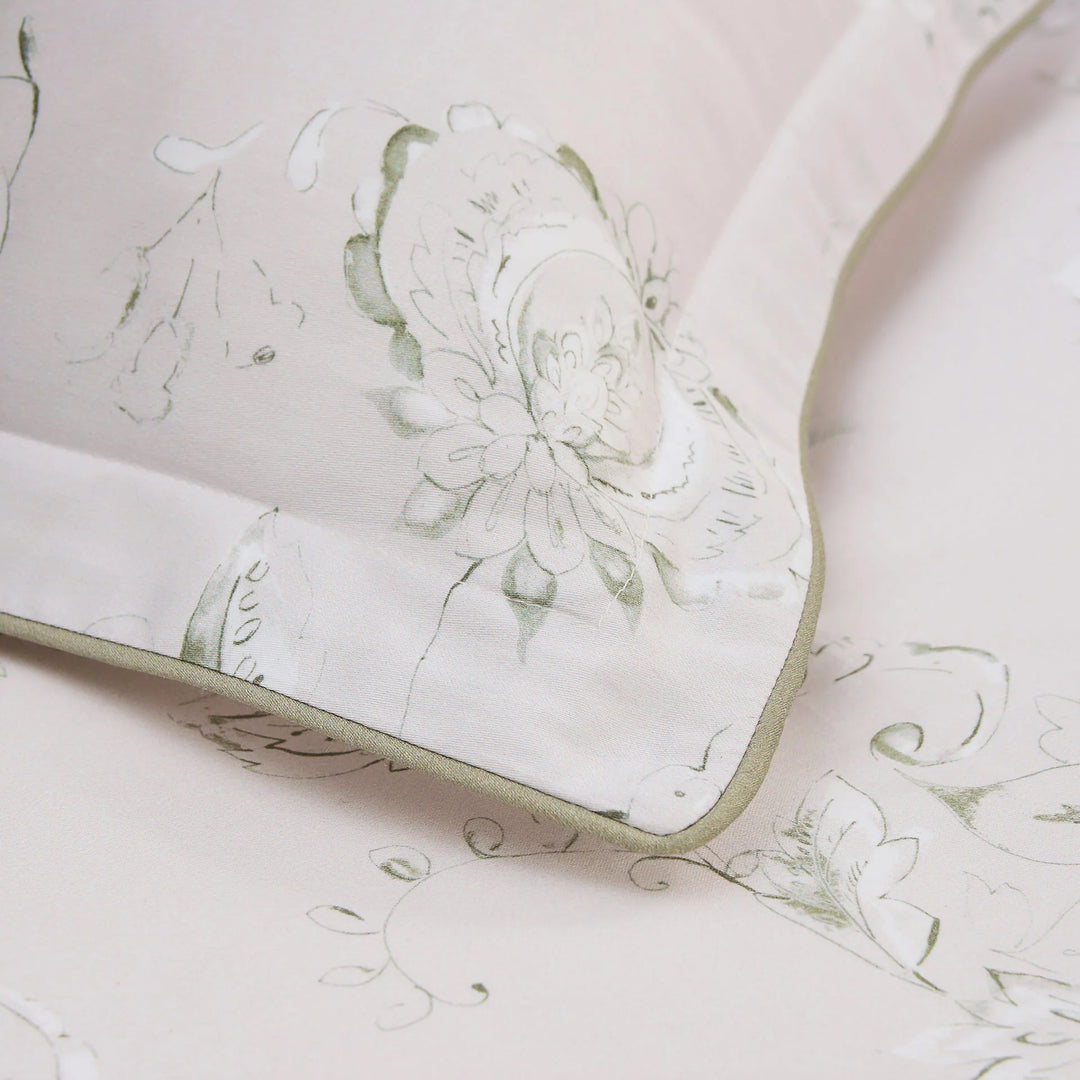 Floral patterned fabric with green accents on a light pink background