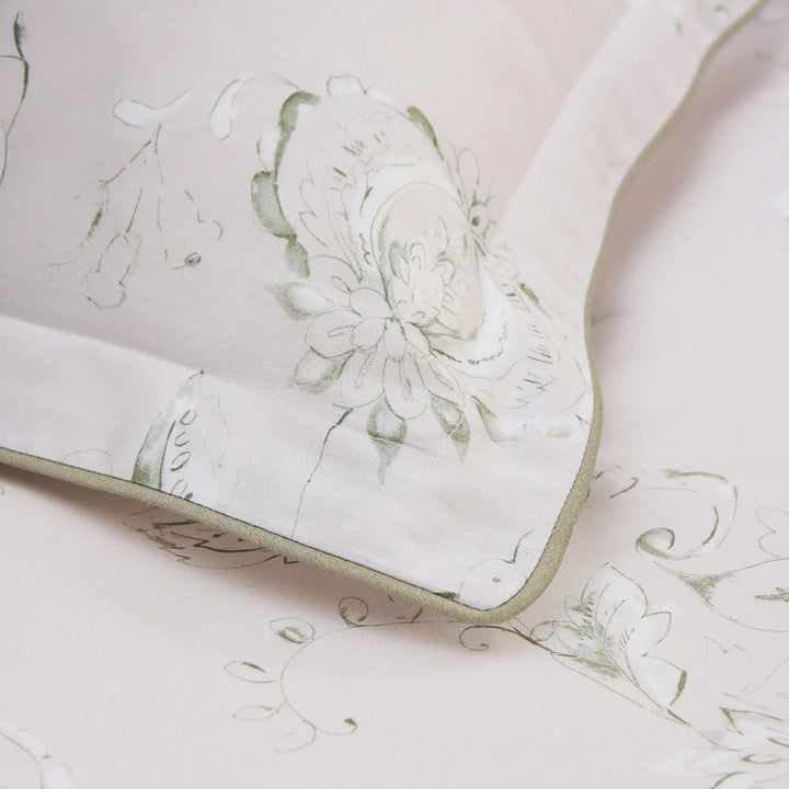 Floral patterned fabric with green accents on a light pink background