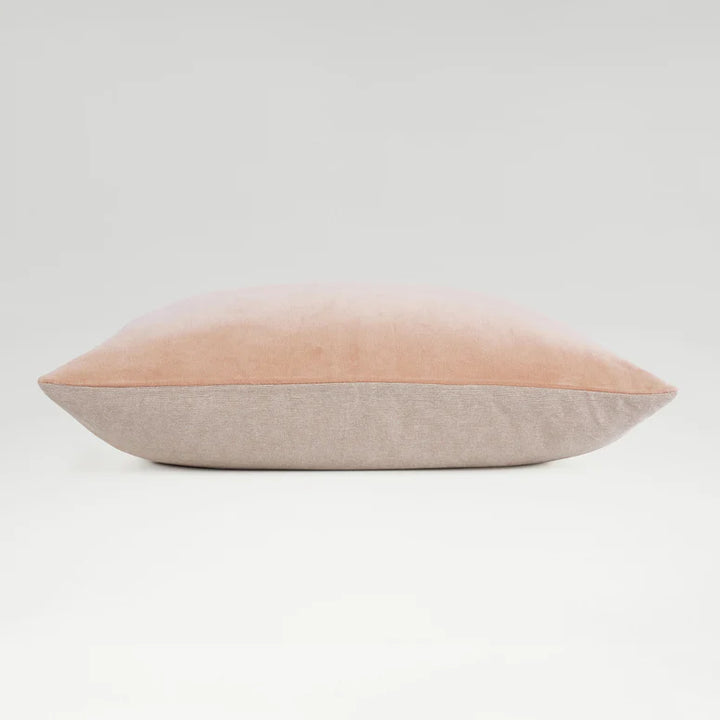 Two-toned pillow with pink top and beige bottom on a light gray background