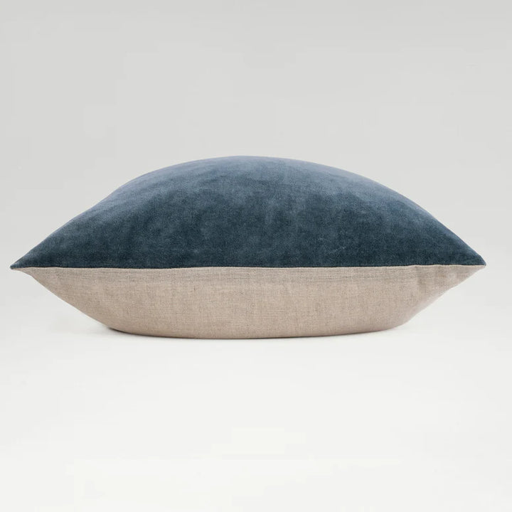 Two-toned pillow with blue top and beige bottom on a light gray background