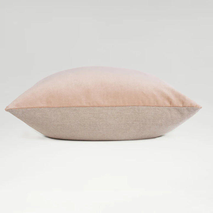 Two-toned pink and beige pillow on a light gray background