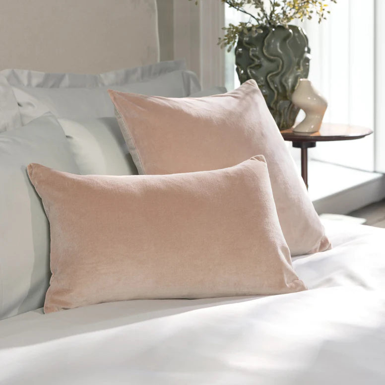 Pink pillows on a bed with a blurred indoor setting