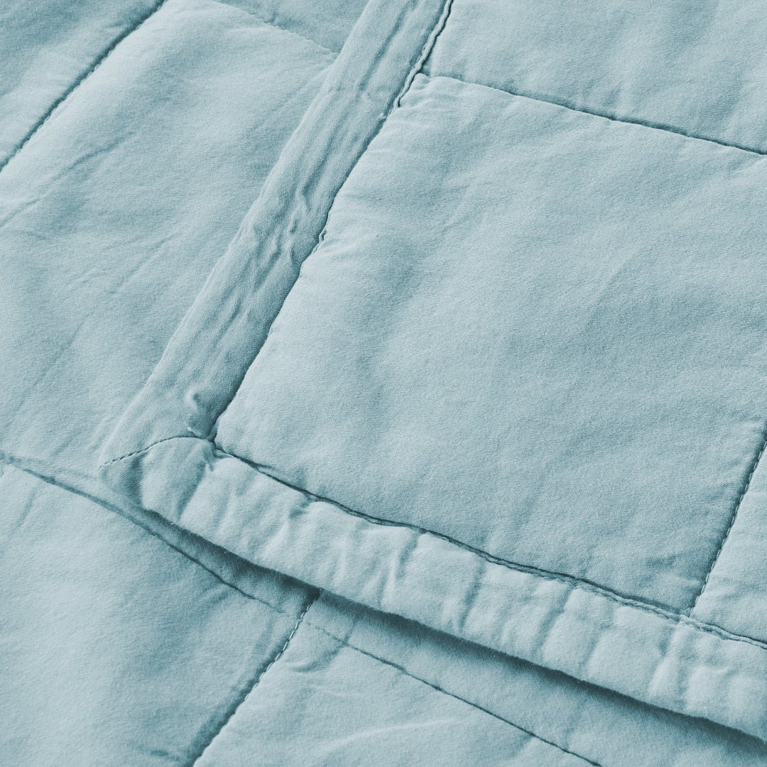 Close-up of a light blue quilted fabric texture
