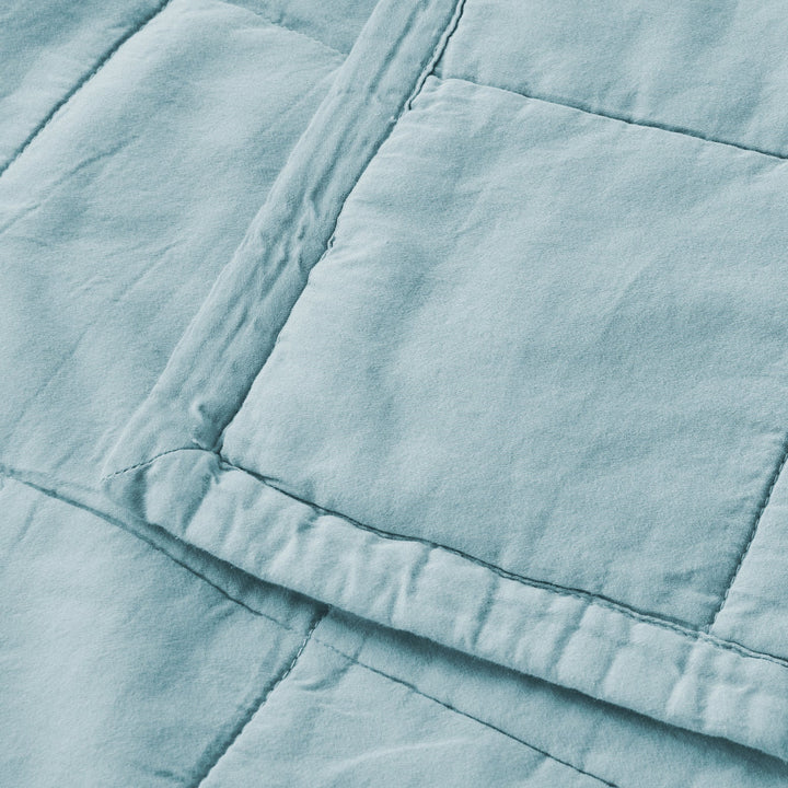 Close-up of a light blue quilted fabric texture