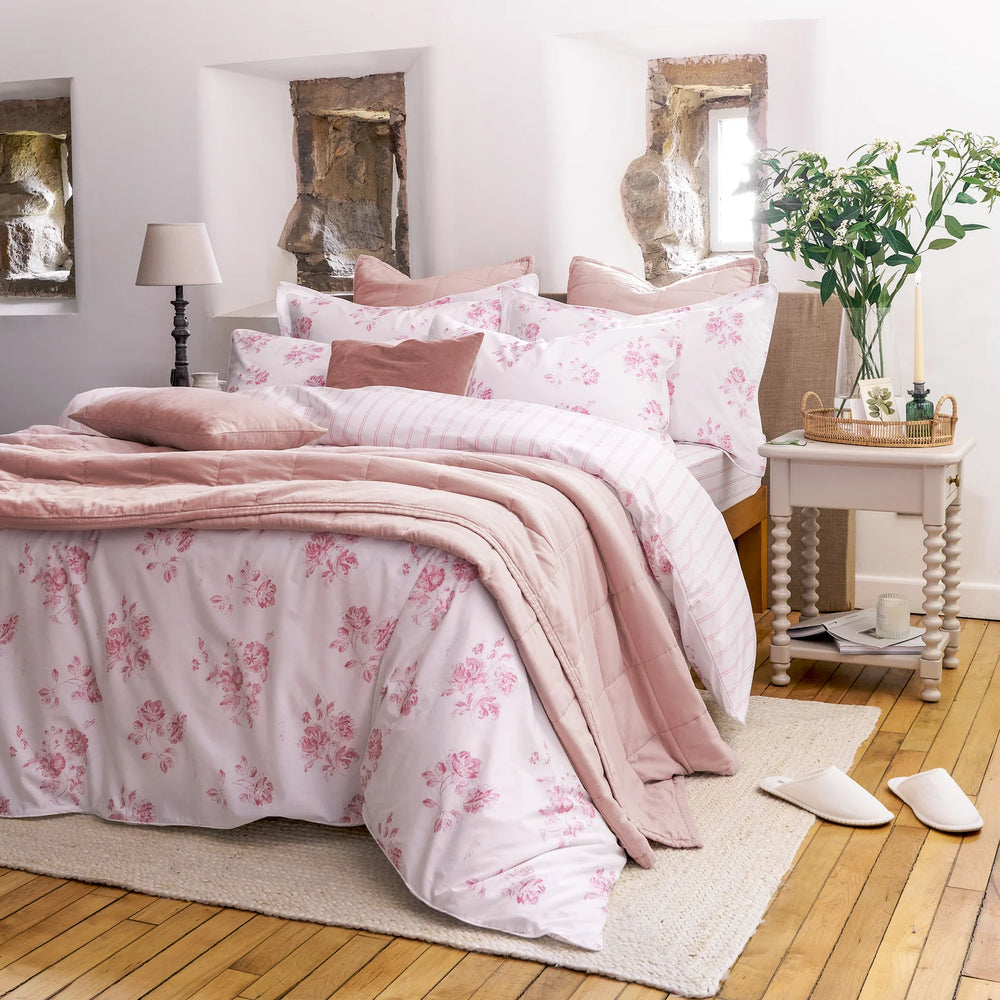 Bedroom with pink floral bedding and wooden floor