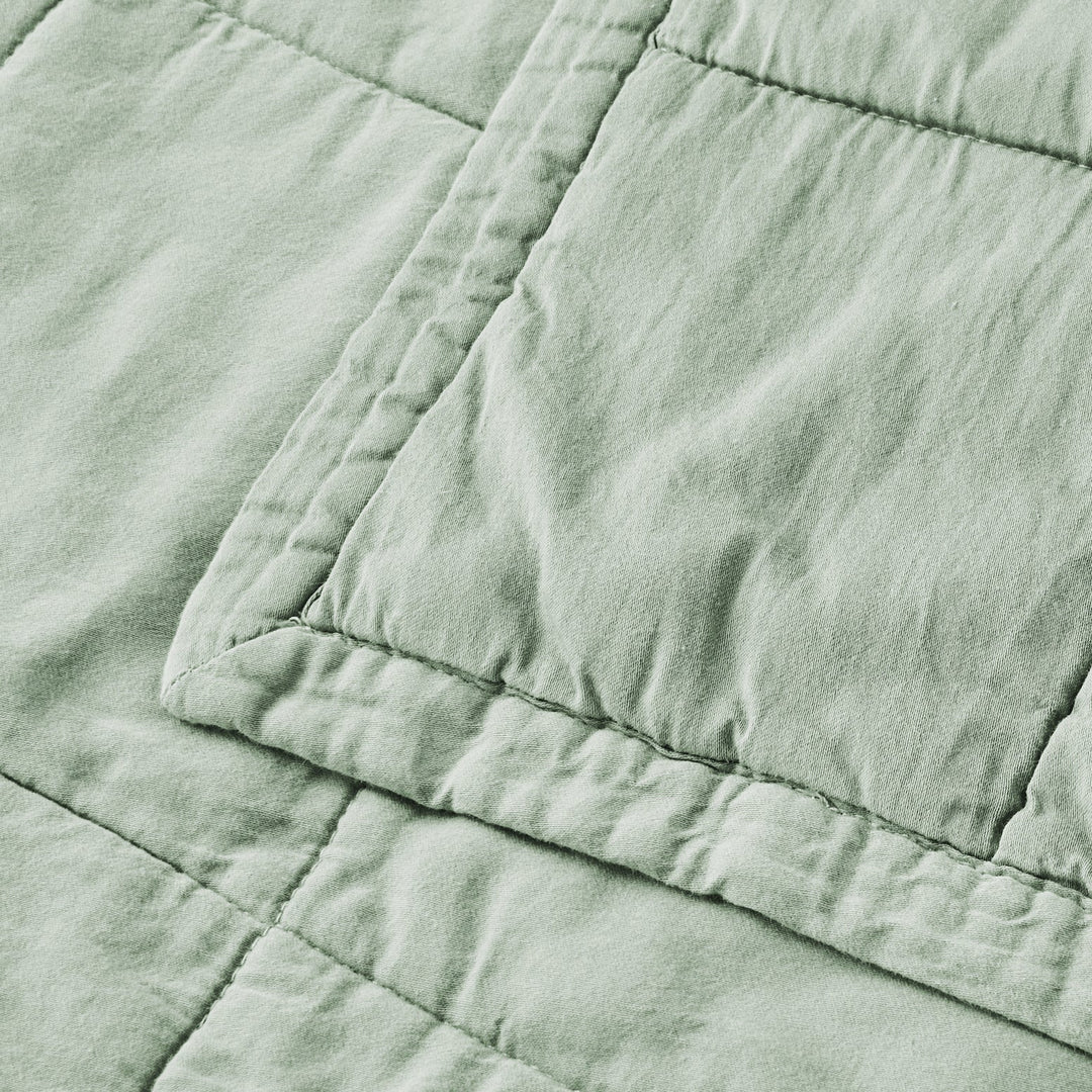 Close-up of a textured green fabric with visible stitching