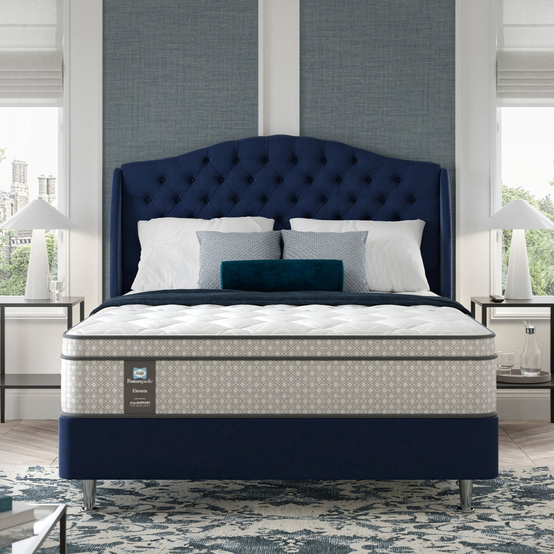 Blue bed in a hotel bedroom with large windows