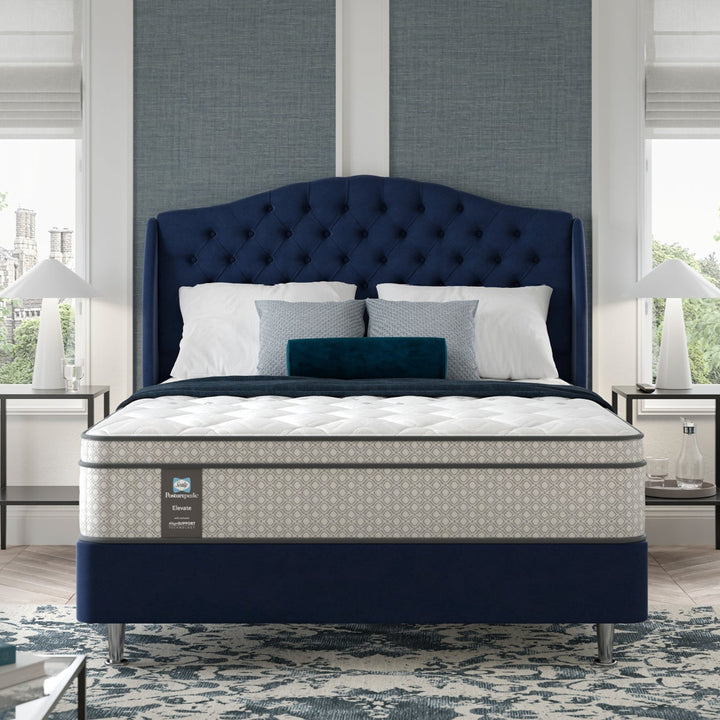 Blue bed in a hotel bedroom with large windows