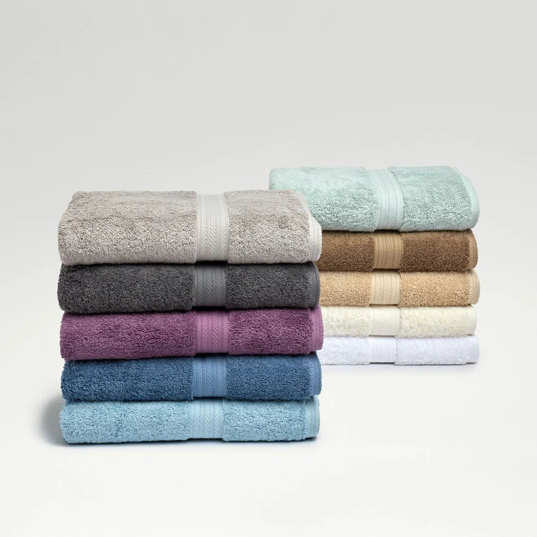 Stack of folded towels in various colors on a light gray background